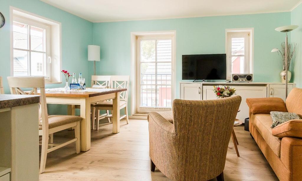 a kitchen and living room with a table and chairs at Wellenzauber in Ahrenshoop