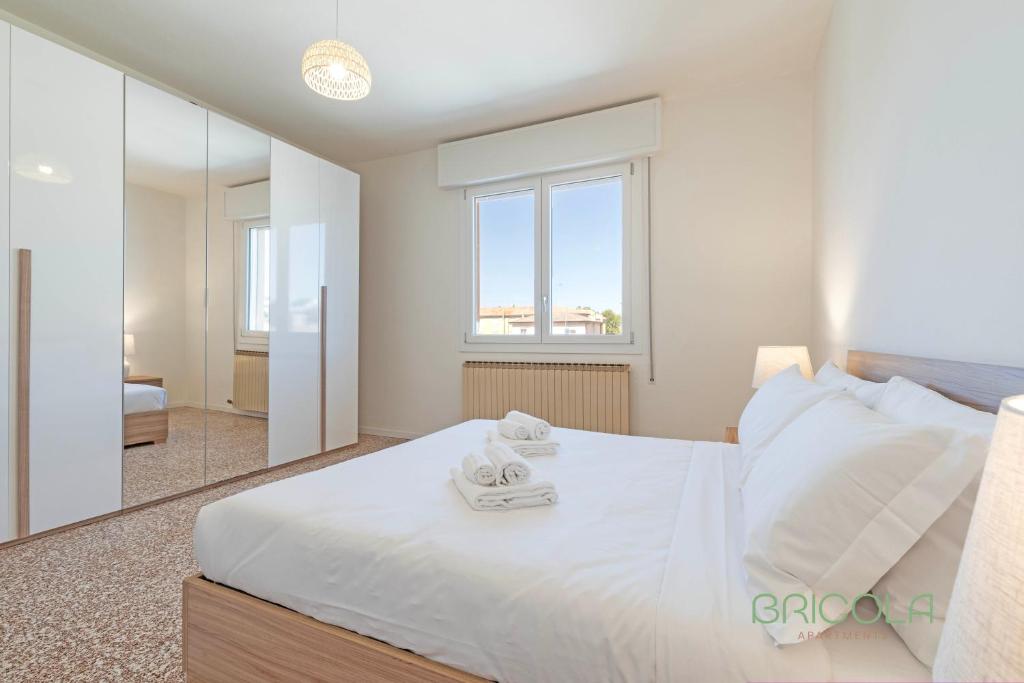 a bedroom with a large white bed with a mirror at Mestre Homey Apartment by Bricola Apartments in Venice