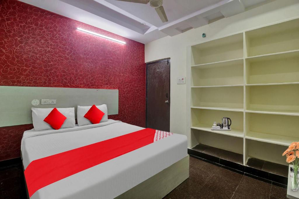 a bedroom with a bed with red walls and shelves at Hotel O Lavish Stay in Hyderabad