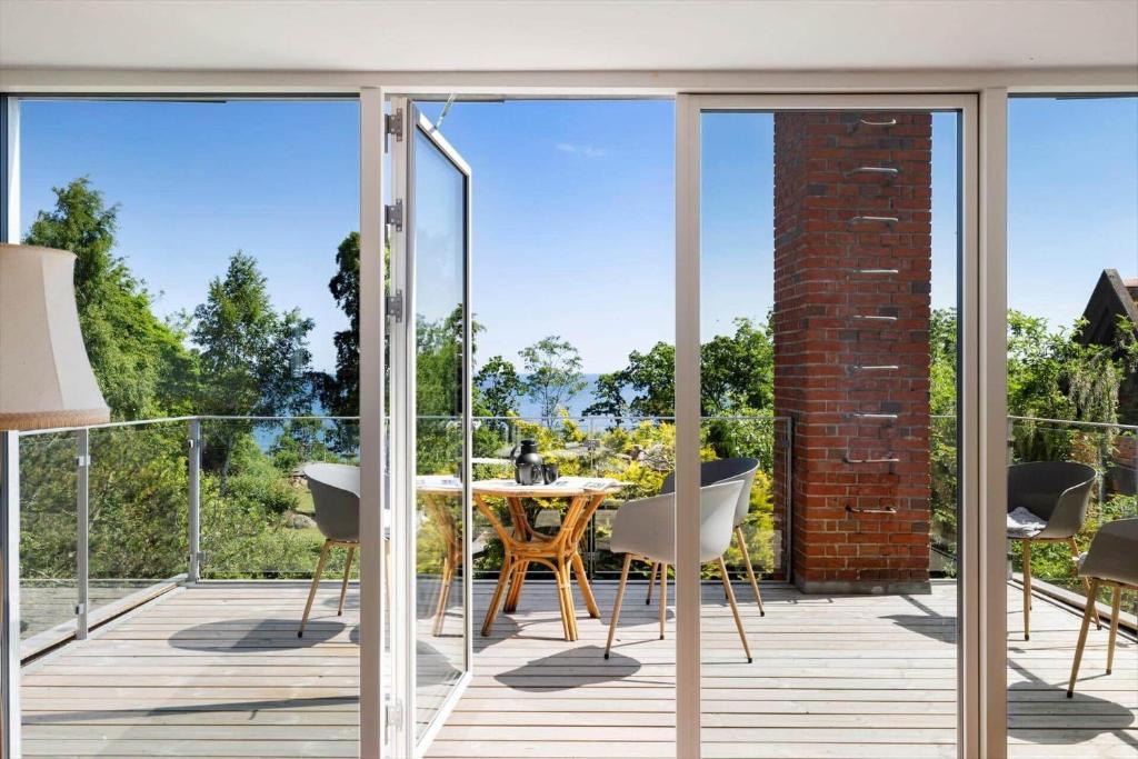 a glass balcony with a table and chairs at 6763-Allinge-Sdr-Strandvej-69 in Allinge