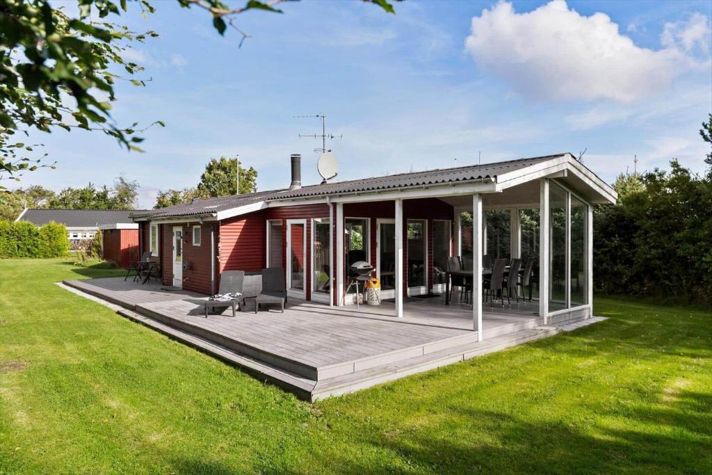 a house with a large wooden deck in a yard at OH526-Hadsund-Ved-Fruerlund-32 in Hadsund