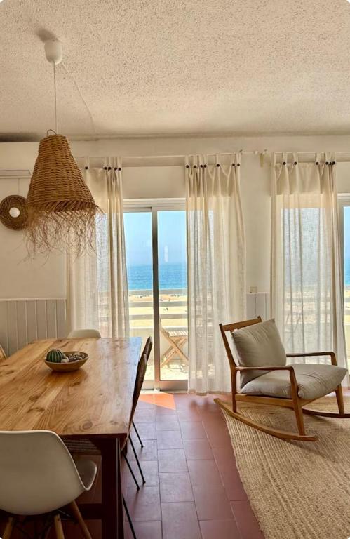 a dining room with a table and chairs and the ocean at Casa Azul in Nazaré