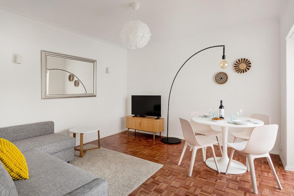 a living room with a table and a couch at Estoril Beach - Your Family Escape in Estoril