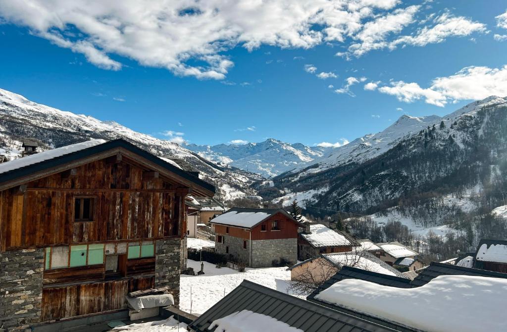 a view of a snowy mountain village with mountains at Chalet spacieux avec vue magnifique in Saint-Marcel