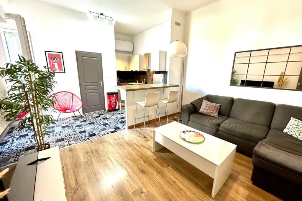 a living room with a couch and a table at Spacious cocoon close to the beach in Ajaccio