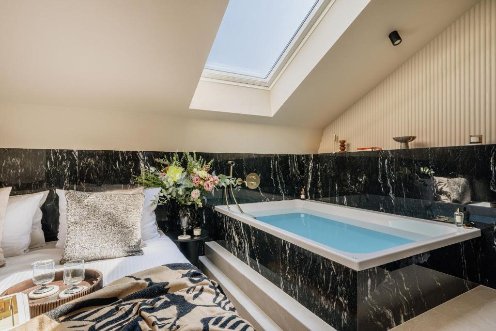 a bathroom with a large tub in the middle at Azure Palace - LoftAffair Collection in Kraków