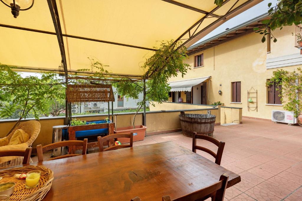 Un patio al aire libre con una mesa y sillas de madera. en La Terrazza Appartamento Agata, en Sirmione