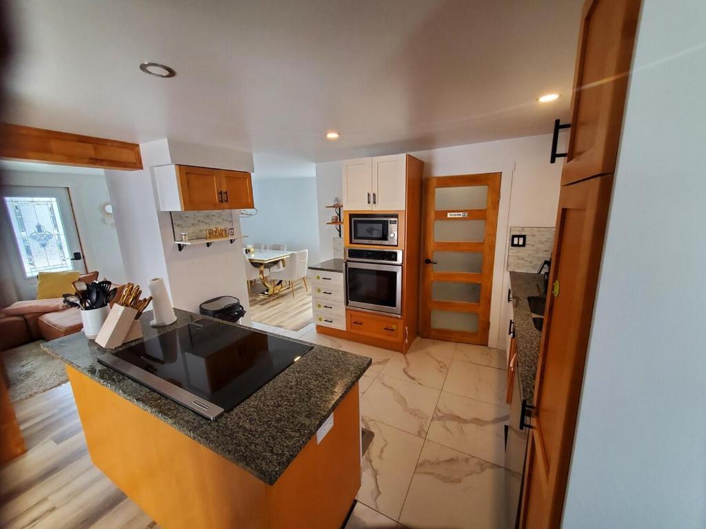 a kitchen with a counter top and a stove top oven at Beautiful Newly Renovated House in Roberval