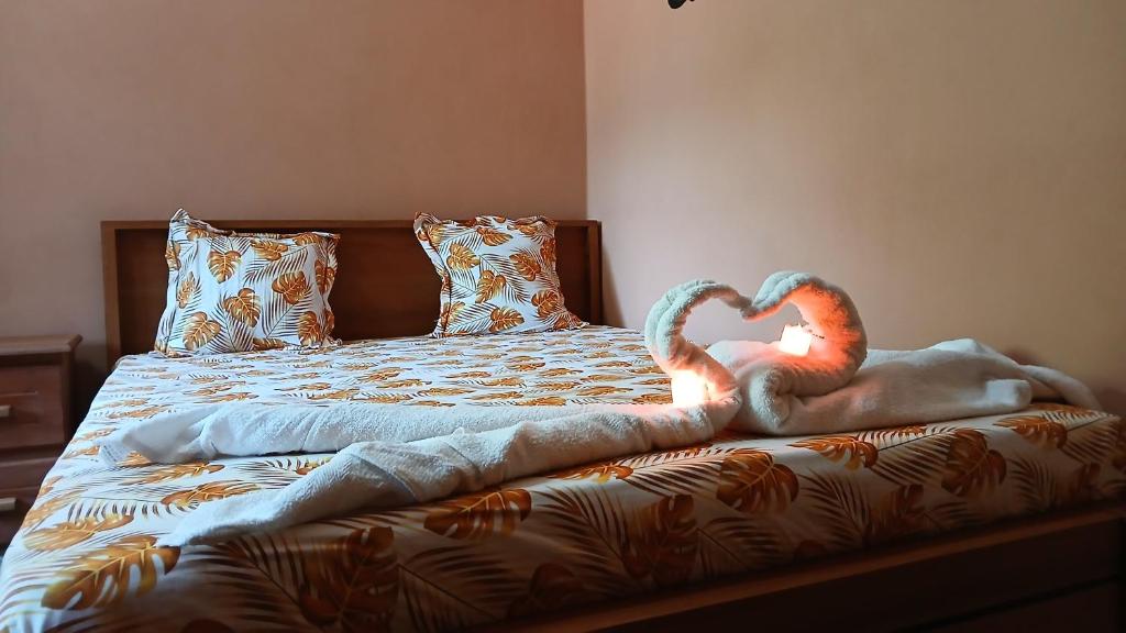 a bed with two animals making a heart on it at CHAMBRE LA TERRASSE Nosy-be in Hell-Ville