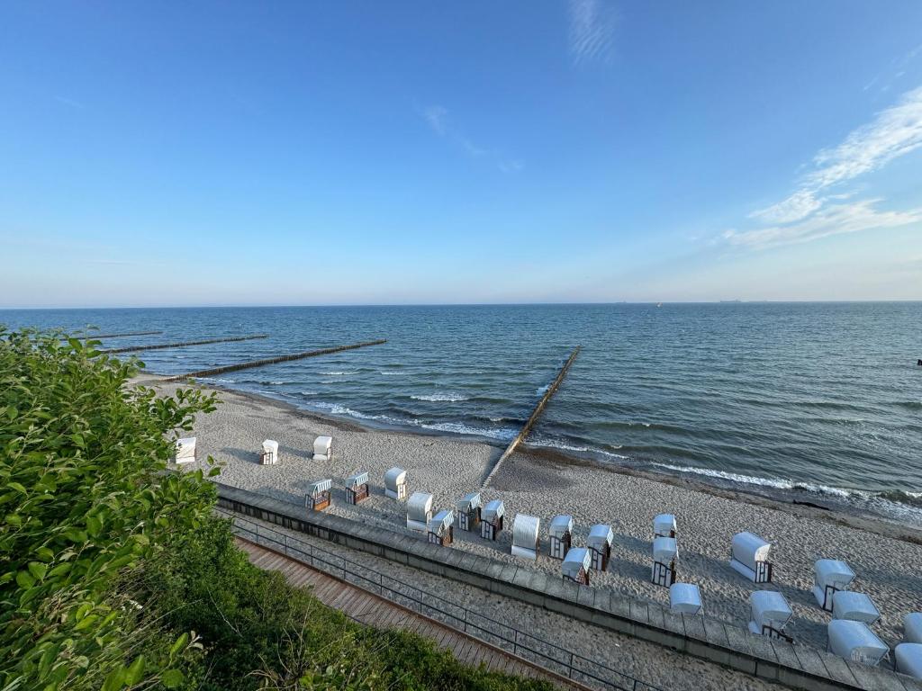 a group of chairs on a beach next to the ocean at Möwennest in Nienhagen