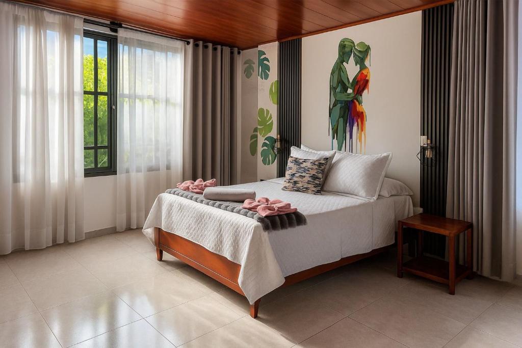 une chambre avec un lit avec un tableau sur le mur dans l'établissement Hotel Wiky House, antes la casona de Wiky, à Guaduas