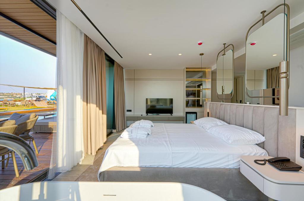 a bedroom with a large bed and a balcony at VENTO MARE LUXURY Hotel in Cesme