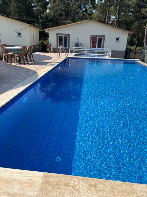 una grande piscina blu davanti a una casa di OLYMPOS YÖRÜK OTAĞI APART EVLERİ a Kumluca