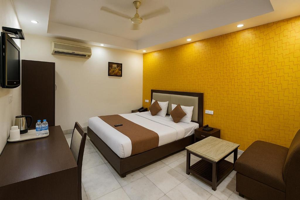 une chambre avec un lit, un canapé et une télévision dans l'établissement Hotel Kingston Park near Ganga Ram Hospital, à New Delhi