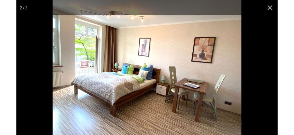 a bedroom with a bed and a table and a window at FeWo Usedom Karlshagen in Karlshagen