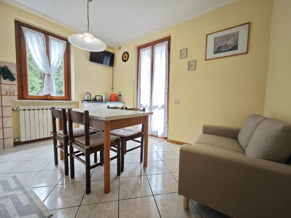 a kitchen and living room with a table and a couch at Terrazza Su Crosio a Clusone in centro! in Clusone