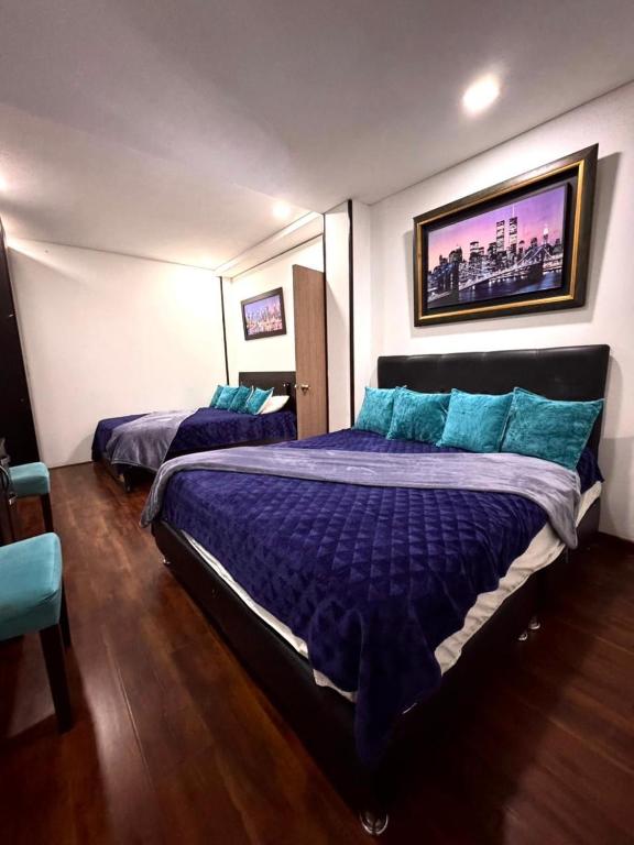 ein Schlafzimmer mit zwei Betten mit blauen Kissen in der Unterkunft Corferias, Apt302 BIG, American Embassy, Agora,Embajada in Estación El Salto