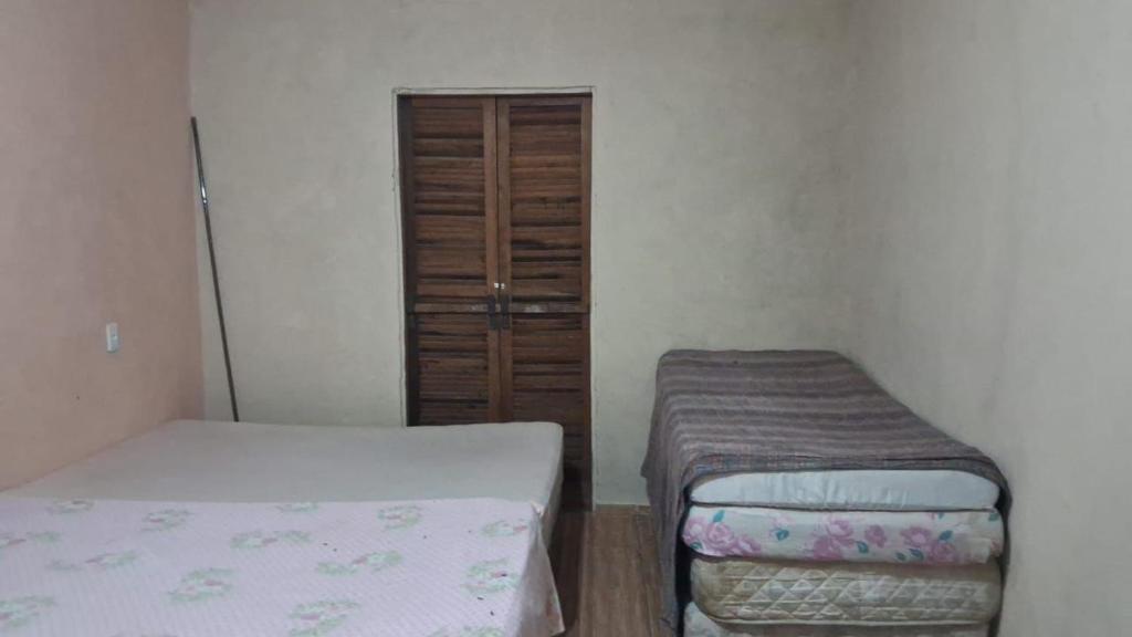 a small room with two beds and a closet at Chácara do vovô kiko in Santana de Parnaíba