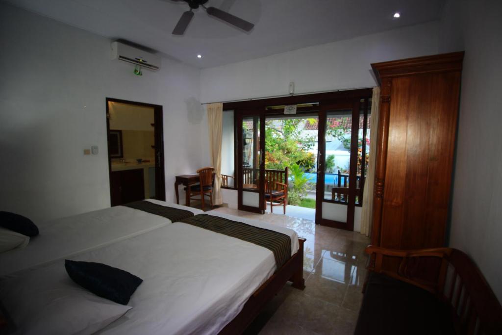 a bedroom with a bed and a room with a window at Pantai Bungalow Lembongan Island in Nusa Lembongan