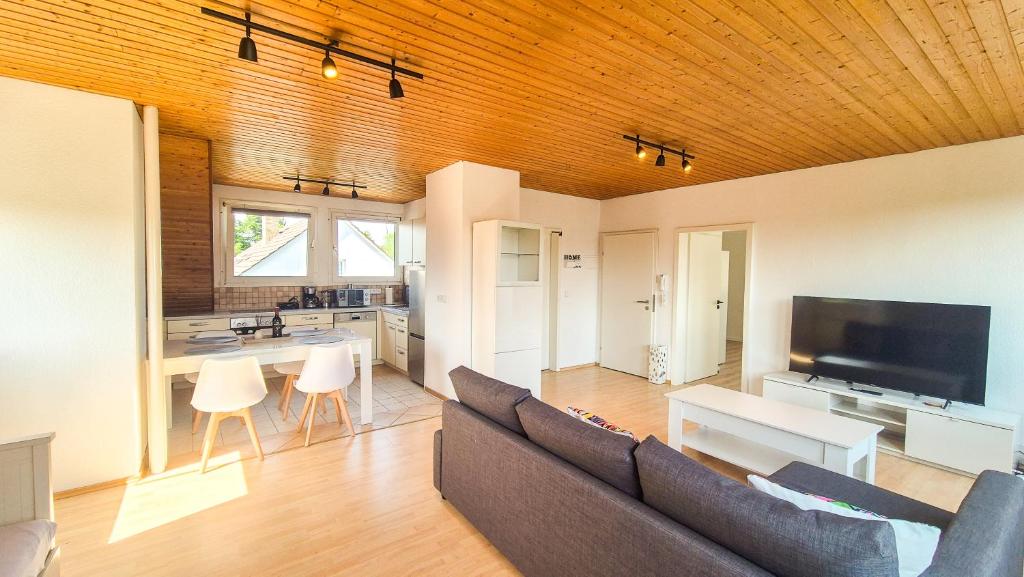 a living room with a couch and a kitchen at Cozy City Apartments 3, 2-Room Flat for Vacation & Messe Düsseldorf, Perfect Connectivity in Ratingen
