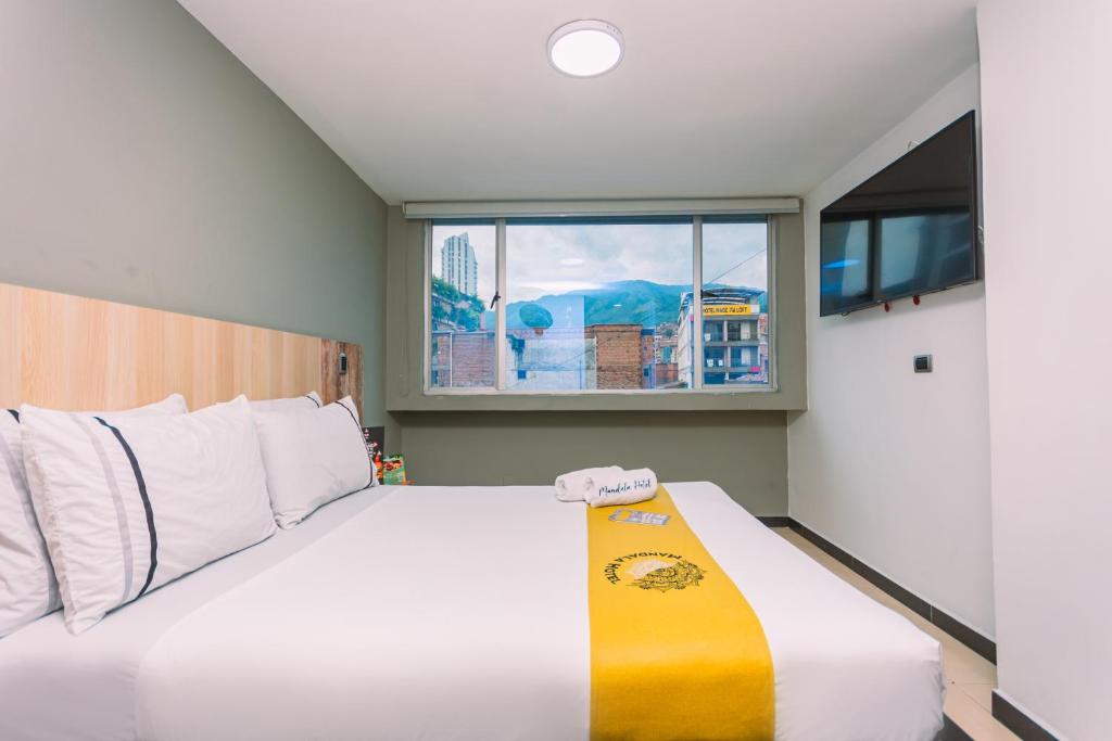 メデジンにあるMandala Hotel Centroの窓のある大きなベッドのある寝室