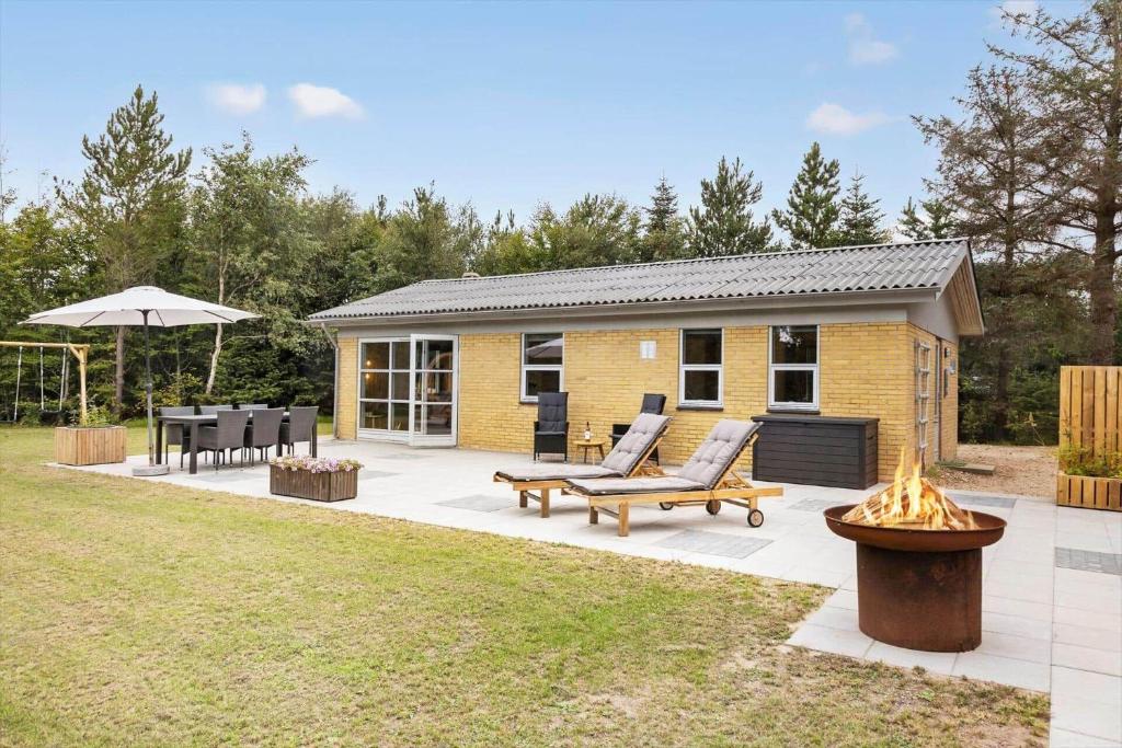 une maison avec un patio avec deux bancs et une table dans l'établissement LF303-Hurup-Thy-Helligsovej-3, à Sønder Ydby