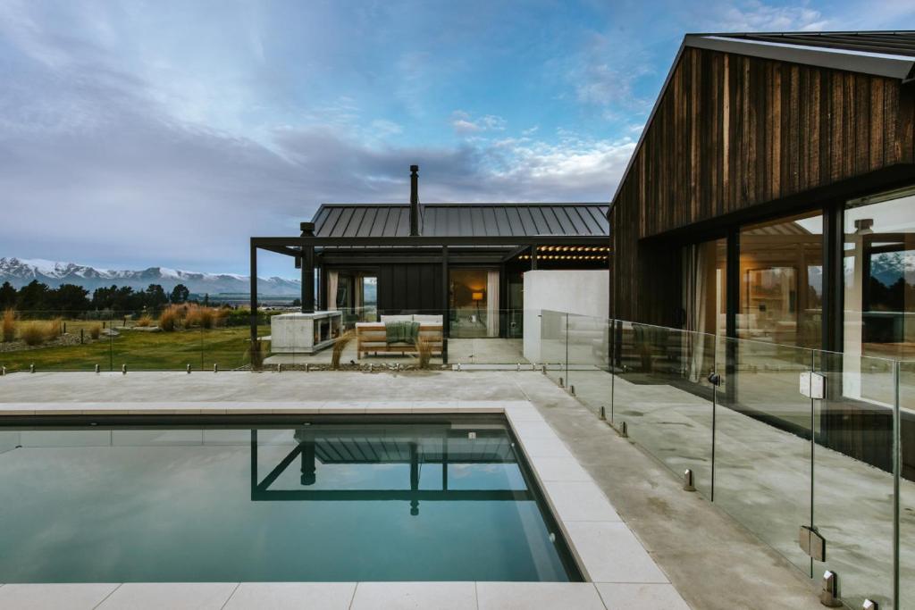 a house with a swimming pool in front of it at Riverslea in Wanaka