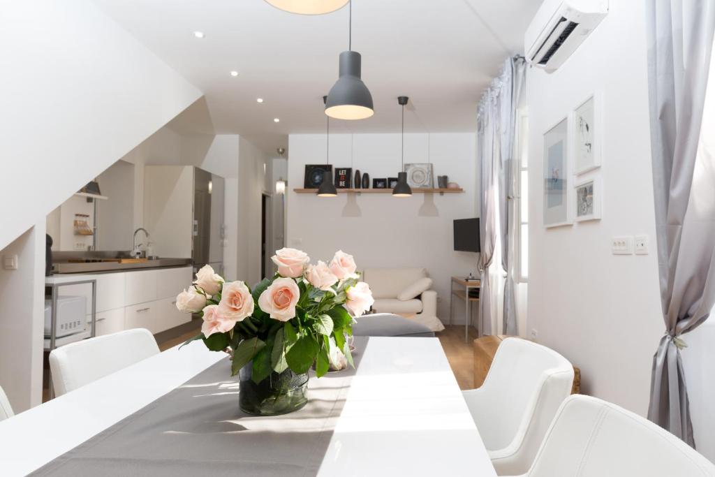 a white kitchen and dining room with a table and flowers at Split Center brand new Apartment Jazzy in Split