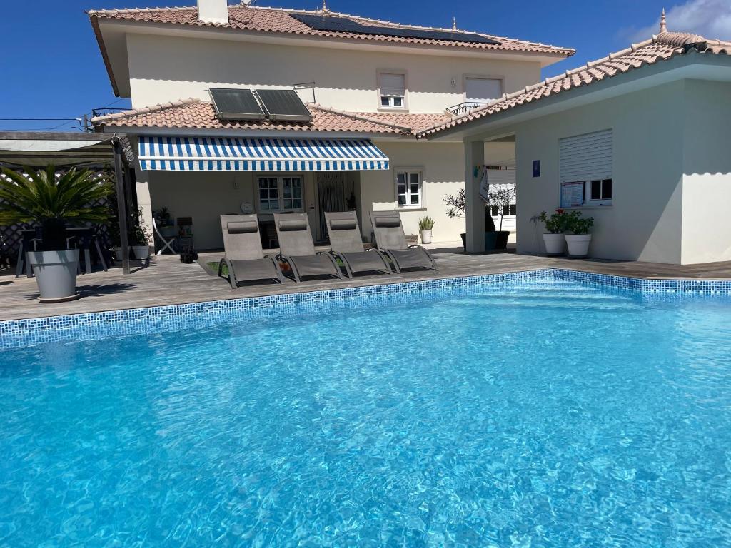 a swimming pool in front of a villa at Casa Magnolia B&B in Gafanha da Nazaré