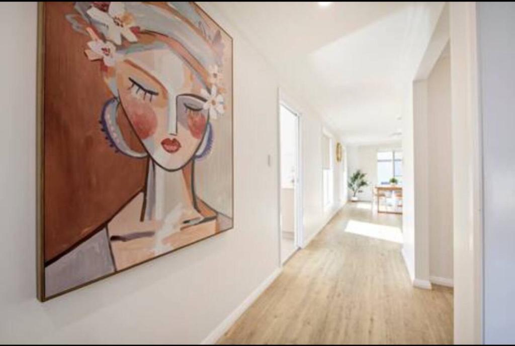 a painting of a woman on a wall in a hallway at Macintyre House in Dubbo