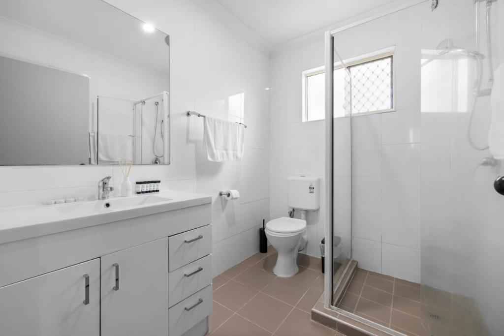 a white bathroom with a shower and a toilet at Soothing Sunny Escape 2B1B AR2 36 in Brisbane