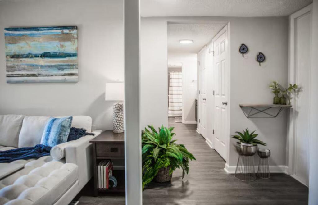 a living room with a white couch and a hallway at The Reserve at Irondale in Birmingham