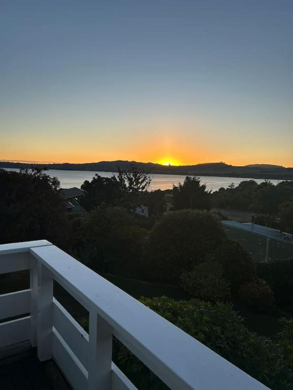 a view of the sunset from the balcony of a house at Modern Townhouse, Stunning Views in Taupo