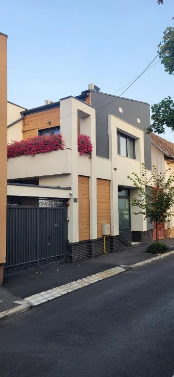 a building with flowers on the side of a street at Casa Belsugului in Târgu-Mureş