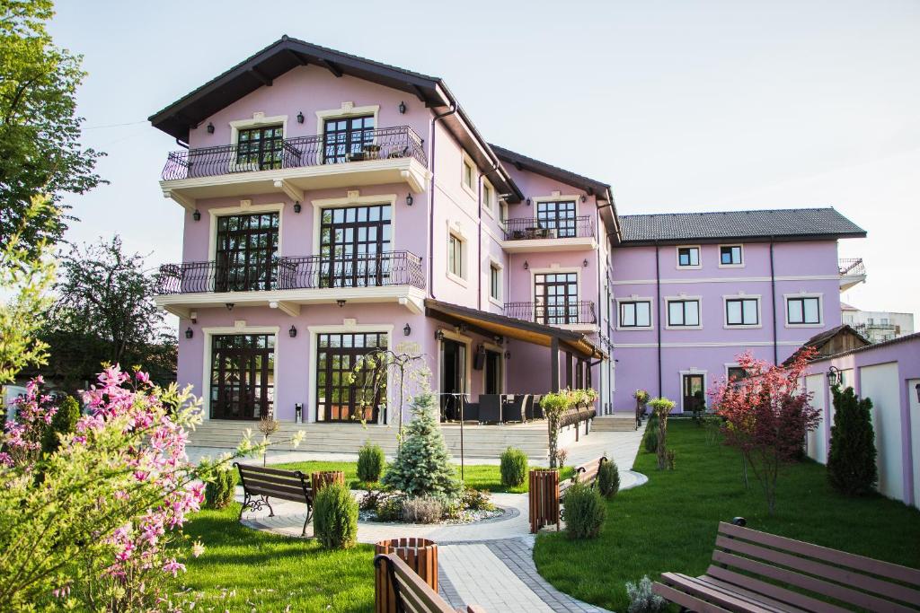 a pink house with a garden in front of it at Marigab in Turceni