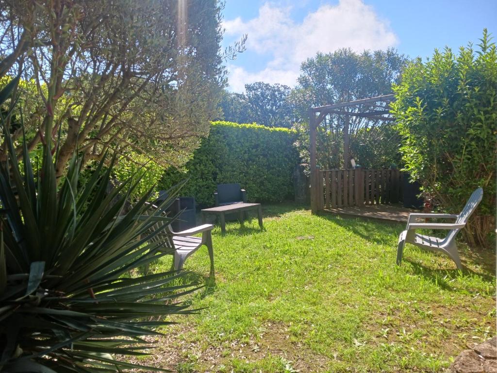 a yard with two chairs and a table in the grass at Maisonnette avec jardin - Séjour détente in Sabran