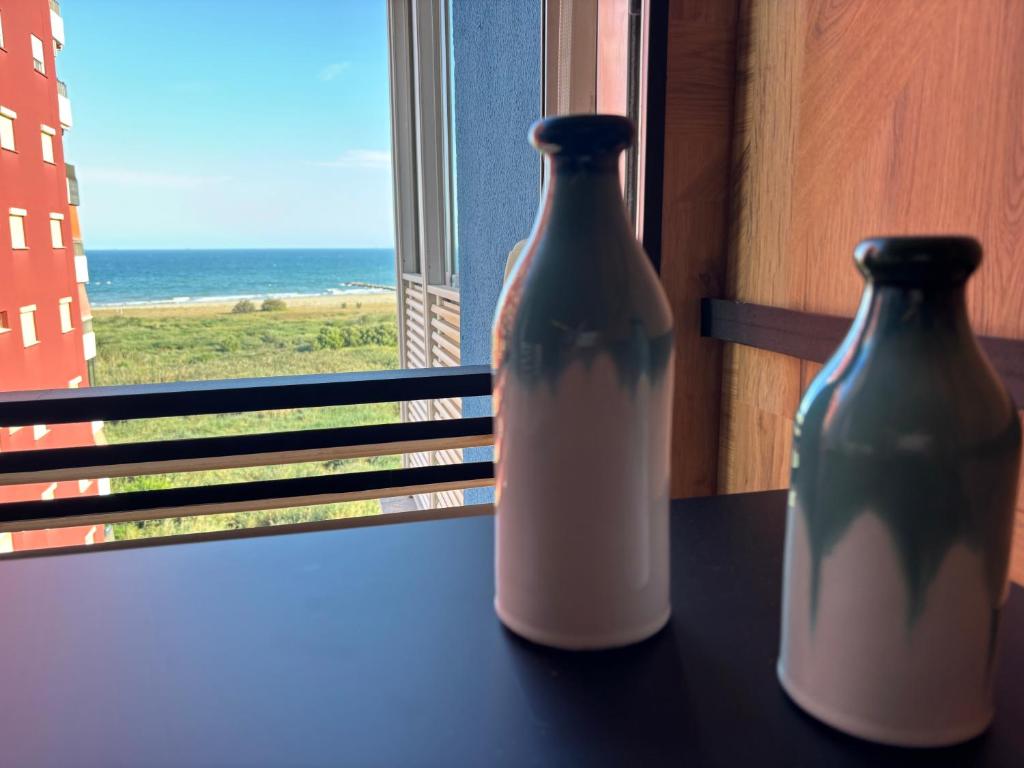 dos jarrones sentados en una mesa frente a una ventana en Farnals Playa Valencia, en Masalfasar