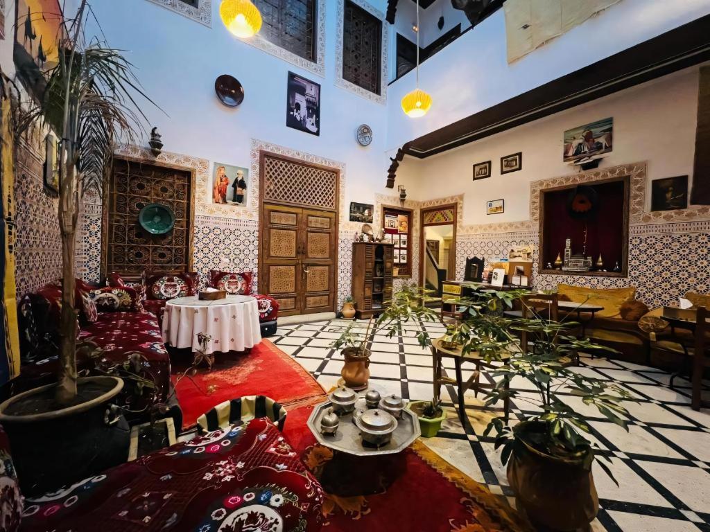 een woonkamer met meubels en een potplant bij Dar Ahl Tadla in Fès