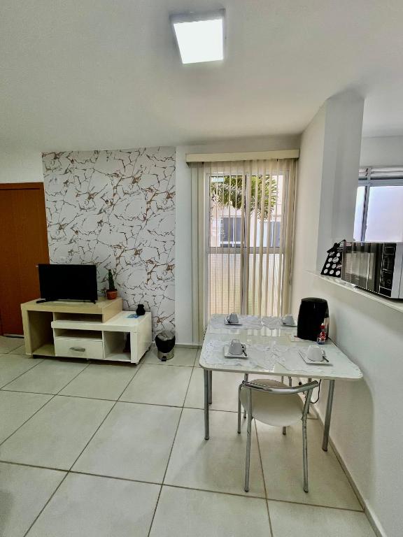 a living room with a table and a tv at Apartamento no térreo para 04 pessoas in Vitória da Conquista