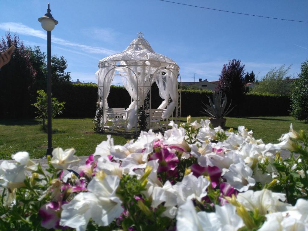 een tuin met een prieel en witte bloemen bij La Valinfiore Charming Home in Montecarlo