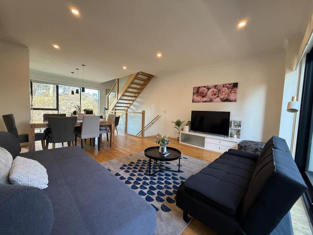 a living room with a couch and a dining room at Modern Port Melbourne 3b3b Townhouse and Parking in Melbourne