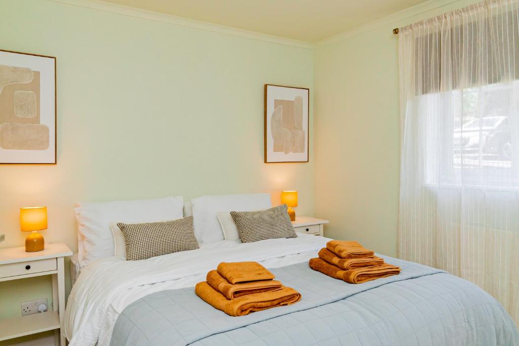a bedroom with a bed with towels on it at Fresh, stylish apartment in Sherborne Saint John