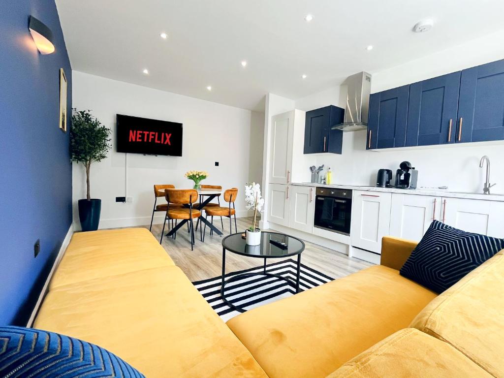 a living room with a couch and a kitchen at Luxury Norwich City Centre Apartment - Free Parking in Norwich
