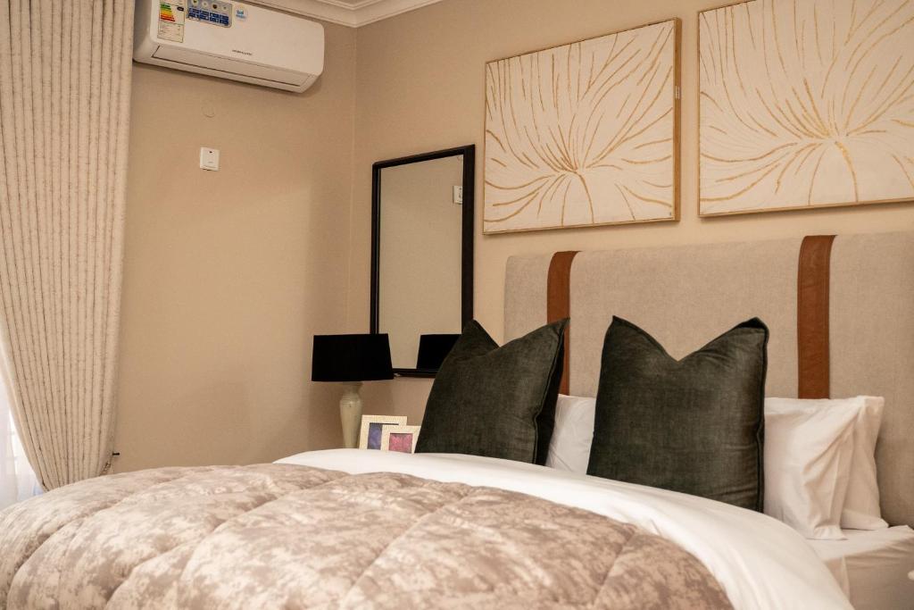 a bedroom with a bed with green pillows at RJV Apartments, Meanwood Ibex Hill, Lusaka in Lusaka