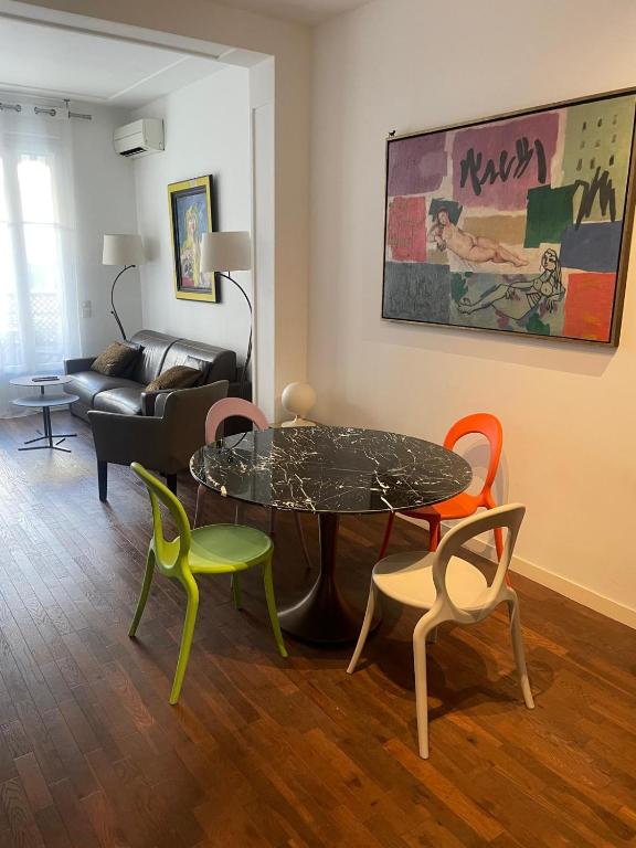 a living room with a table and four chairs at Appartement moderne 4p hypercentre de nice in Nice