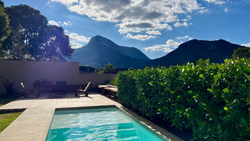 a backyard with a swimming pool and mountains at Casa 08 Monte Boa Vista - Piscina Privativa, Sauna e Ofurô de Imersão in Teresópolis