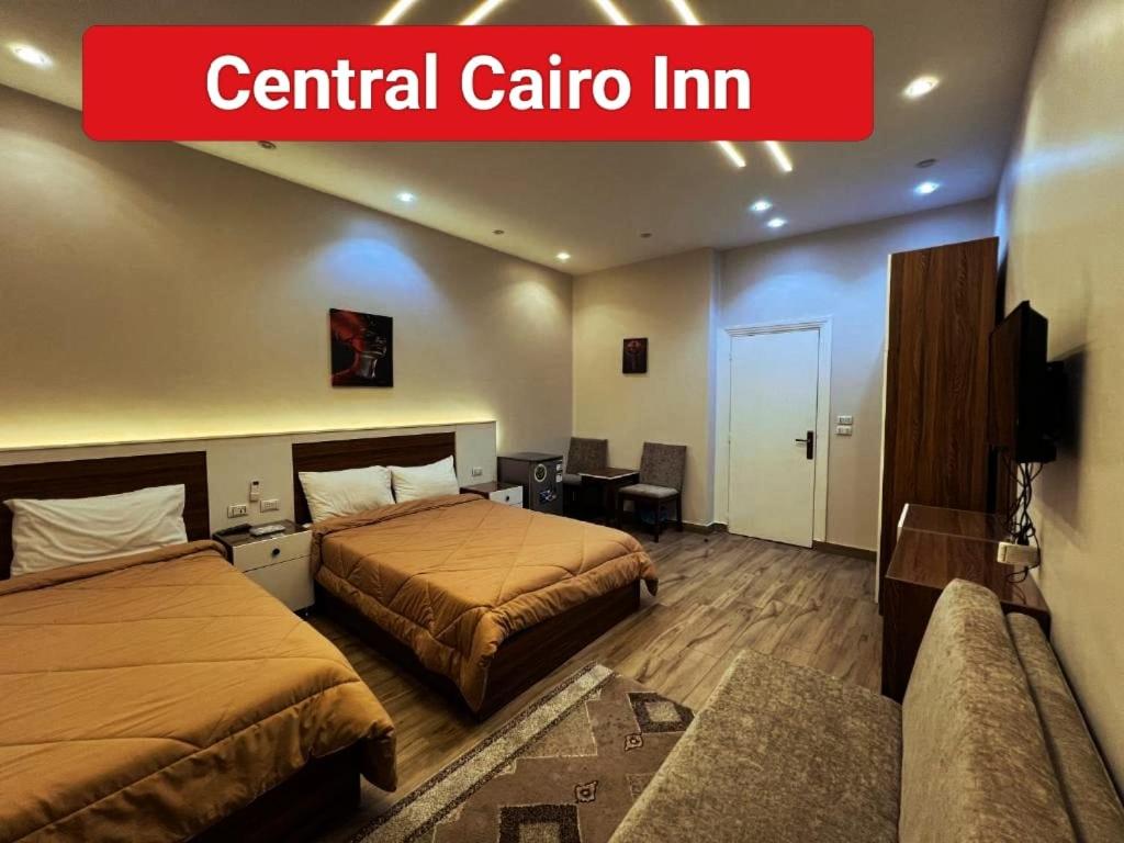 a hotel room with two beds and a sign that reads central calico inn at Central Cairo Inn in Cairo