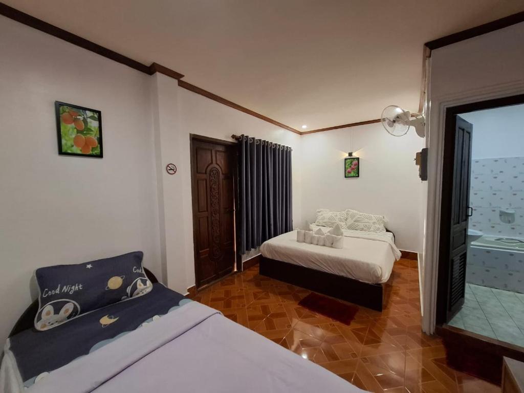 a bedroom with two beds and a mirror at vangvieng SCK Hotel in Vang Vieng