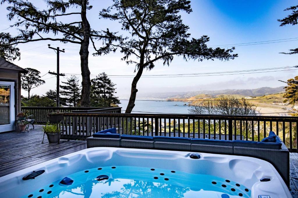 a hot tub on a deck with a view of the water at Coastal Charm - Oceanview Stay in Pacifica Near SF in Pacifica