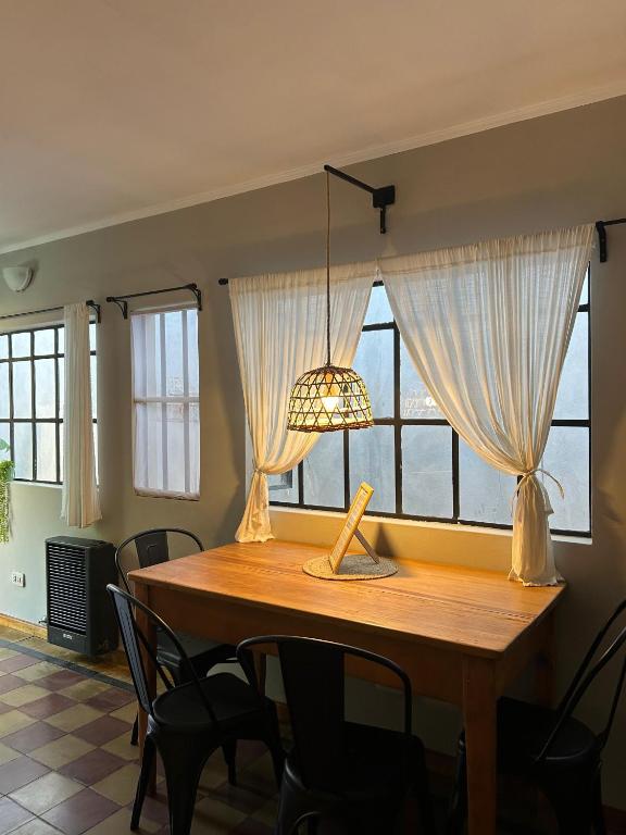 een eettafel met een lamp en ramen bij Casita de Barrio in Lobos